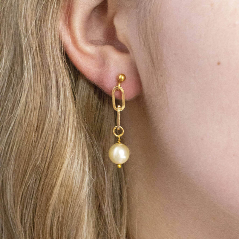 Model wears chunky chain Swarovski pearl drop earring 