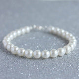 Classic pearl bracelet on grey glitter background