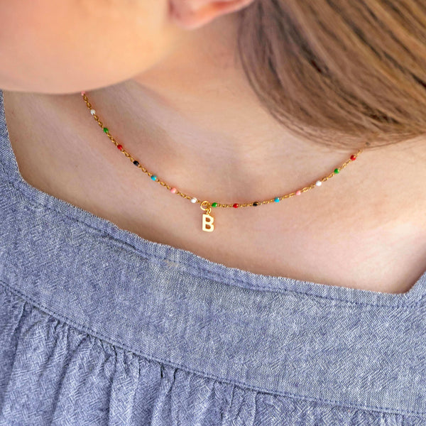 Image shows model wearing colourful beaded initial charm necklace with the initial B
