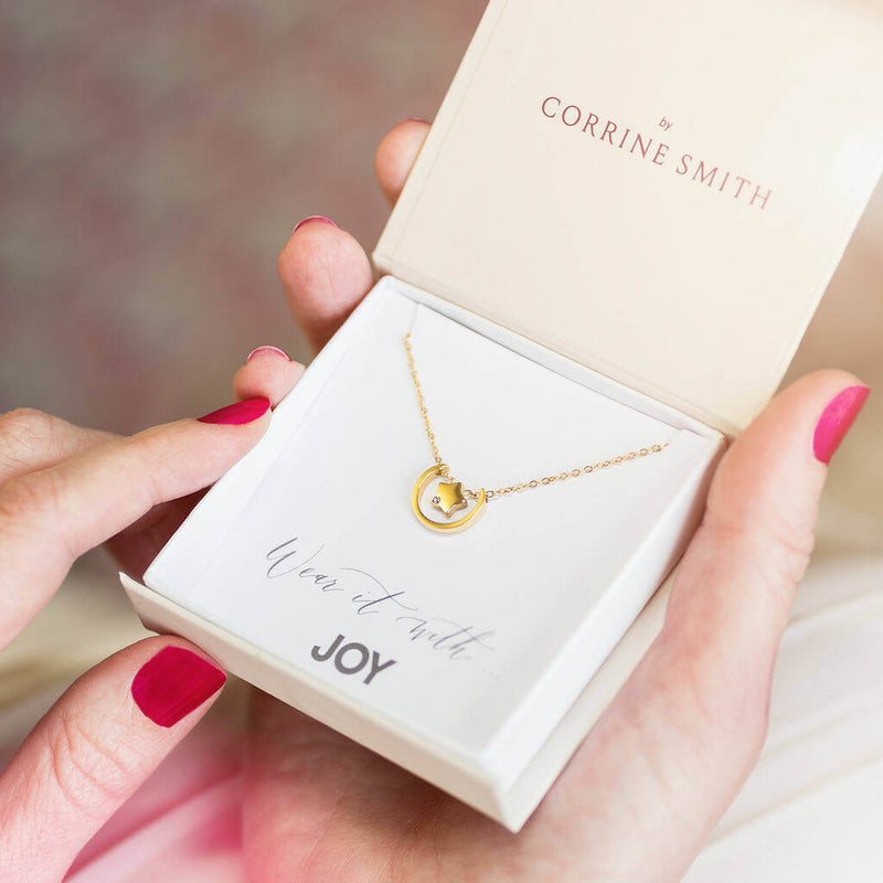 Image shows Contemporary Moon And Star Floating Necklace in a gift box on a Wear it with JOY sentiment card