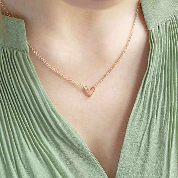 Image shows model wearing rose gold Dainty Crossed Heart Pendant