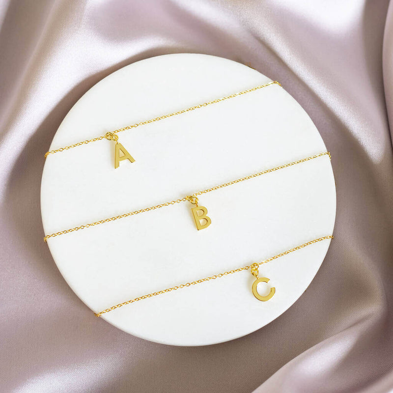 Image sows three Dainty Gold Plated Initial Necklaces with  A B and C initials