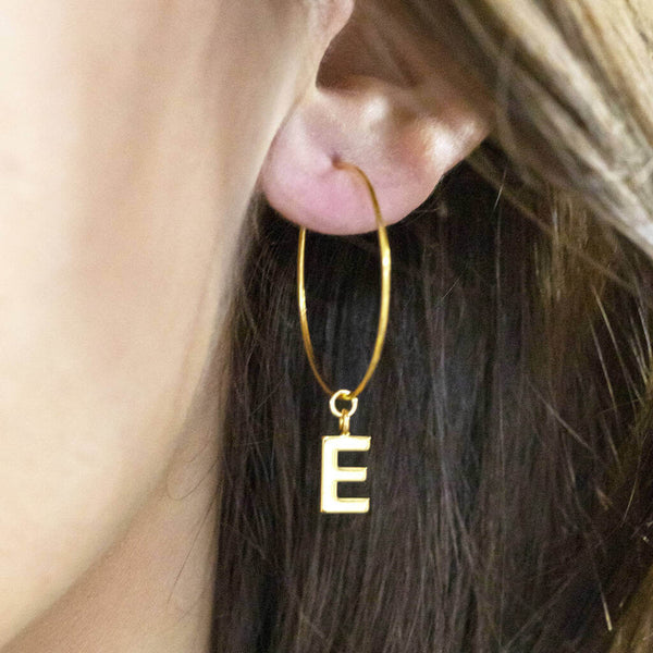 Image shows model wearing Dainty Initial Charm Hoop Earring with initial E 