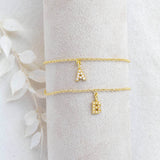 Two gold dainty pearl initial charm bracelet with the initial A and B