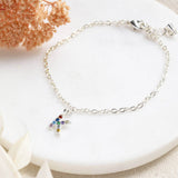 Image shows silver dainty rainbow initial charm bracelet with K initial
