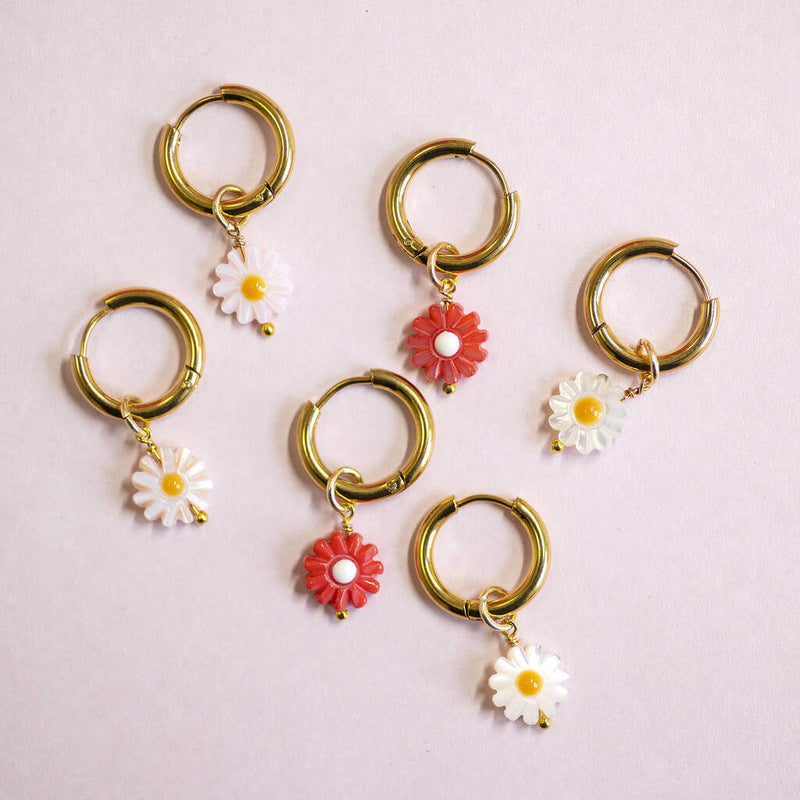 Image shows  daisy charm Huggie hoop earrings