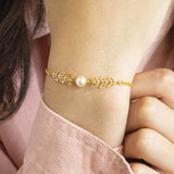 Model wears delicate leaf outline pearl bracelet