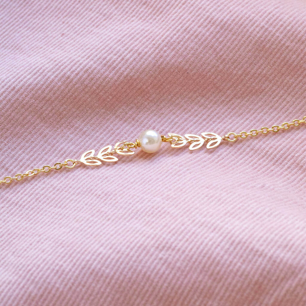 Delicate leaf outline pearl bracelet lying on pink cord