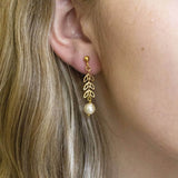 Model wears delicate leaf outline pearl drop earring