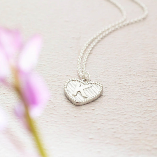 Image shows silver dotted heart initial charm necklace with the initial K