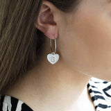 Image shows model wearing silver dotted heart initial hoop earring with initial B