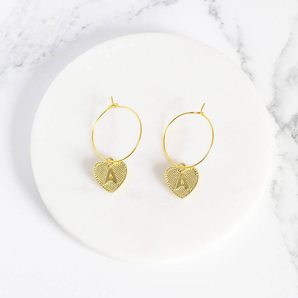 Image shows gold dotted heart initial hoop earrings with initial A
