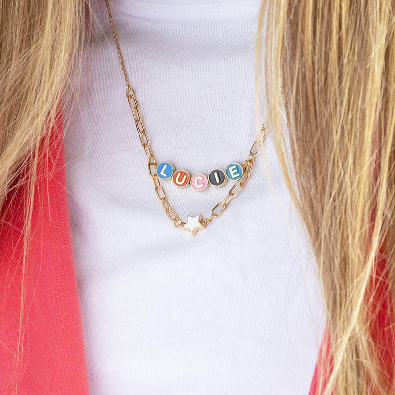 Image shows model wearing Draped Enamel Name Necklace with Star Detail with the name Lucie
