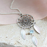 Image shows Dreamcatcher Birthstone Necklace on a stone coaster
