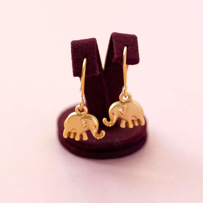 Image shows elephant charm drop earrings on maroon earring holder