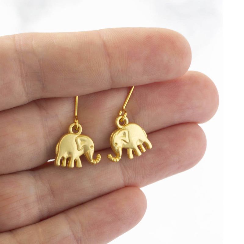 mage shows model holding elephant charm drop earrings 