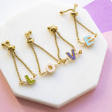 Image shows four enamel initial adjustable chain ring with initials L O V E