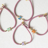 Image shows four Enamel Initial Cord Bracelet with initials M,Z,H and K
