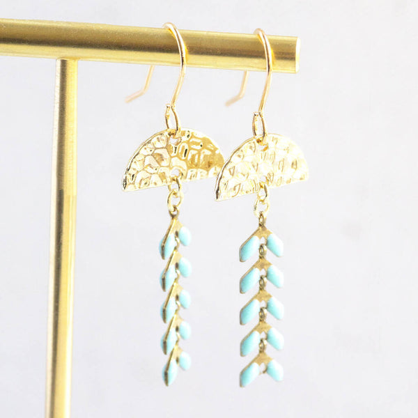 Image shows Enamel Leaf Chain Drop Earrings hanging on a gold earring stand