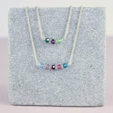 Image shows two family birthstone bar necklace
