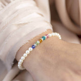 Model wears family birthstone pearl bracelet with Sapphire,Peridot,Topaz,Blue Zircon and Rose birthstone with diamond spacers