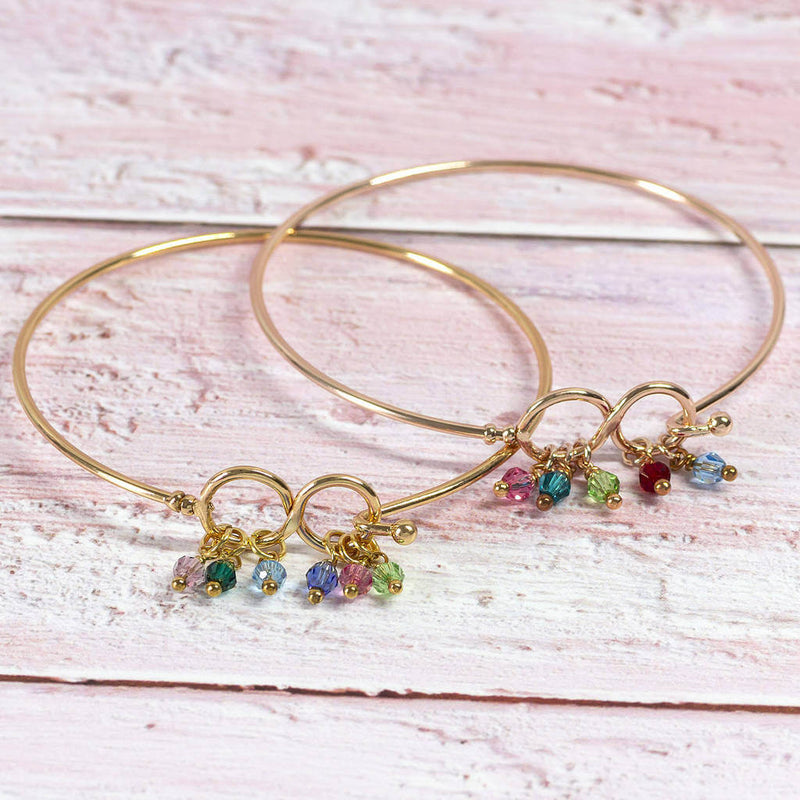Image shows two gold family infinity birthstone bangle