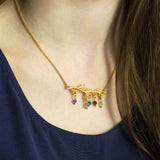 Images shows model wearing family tree branch birthstone necklace