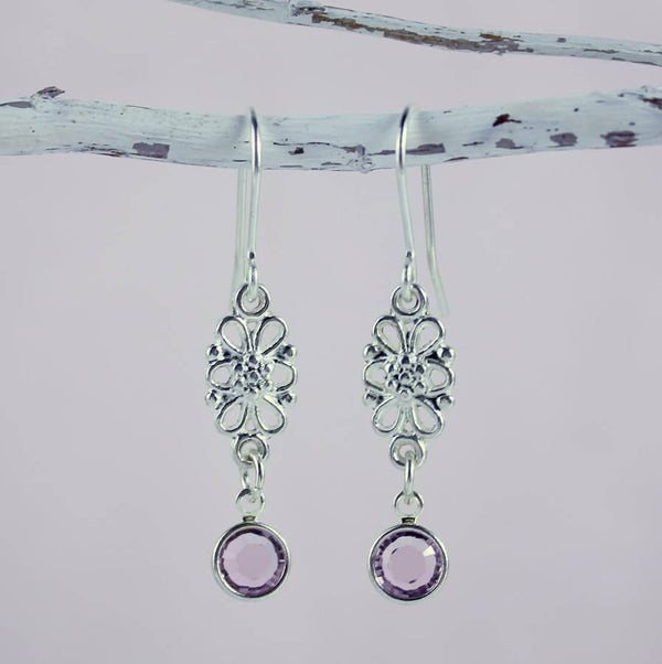 Image show silver Filigree Swarovski Crystal Birthstone Earrings  hanging from small white twig