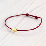 Image shows friendship bracelet with gold heart detail