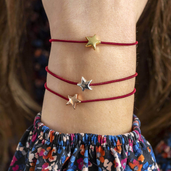 Image shows model wearing gold, silver and rose gold friendship bracelet with star details