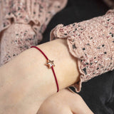 Image shows model wearing rose gold friendship bracelet with star detail