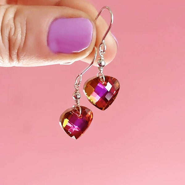 Image shows model holding pink Glam Crystal Drop Earrings
