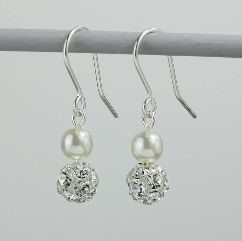 Glitterball and pearl earrings hanging on a small grey pole
