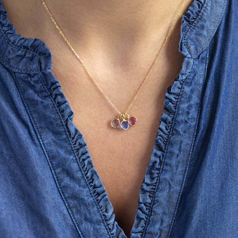 Image shows model wearing gold family birthstone charm pendant necklace
