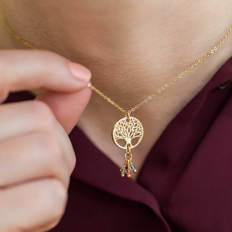 Image shows model wearing gold family tree charm necklace with birthstones