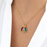 Model wears gold family marquise style birthstone necklace with Swarovski birthstones: January Garnet, April crystal and December blue zircon