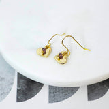 Image shows gold heart birthstone charm earrings with February birthstone