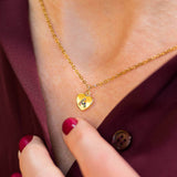 Image shows model wearing gold heart necklace with rainbow initial A