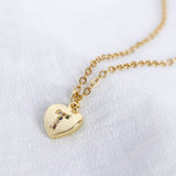 Image shows gold heart necklace with rainbow alphabet letter T