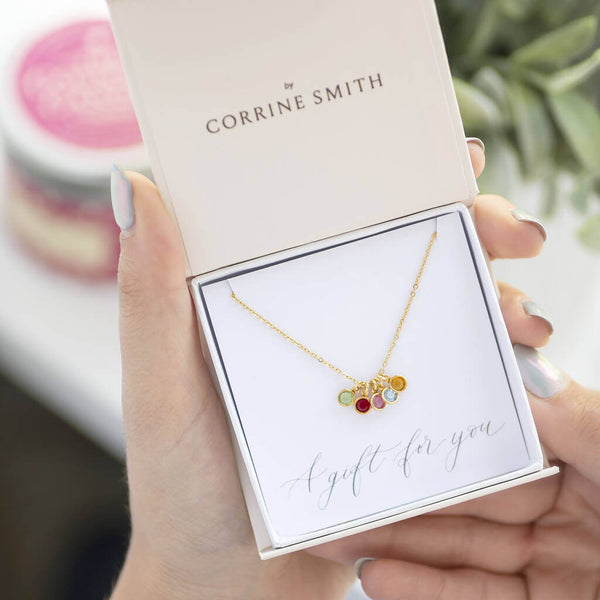 Image shows gold mini family birthstone charm necklace  in a gift box on a gift for you  sentiment card