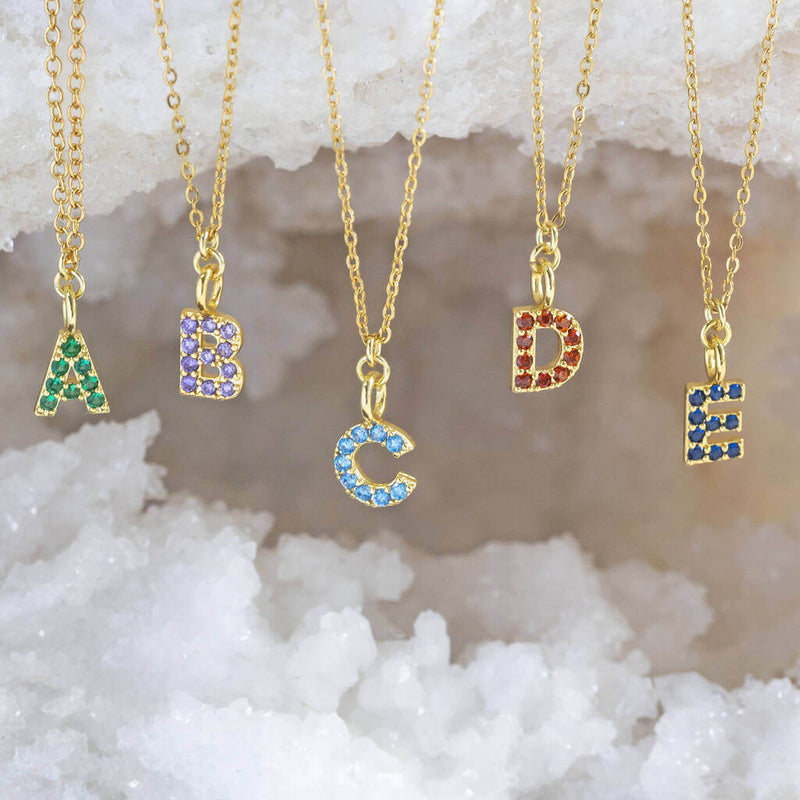 Image shows a selection of gold birthstone initial necklace