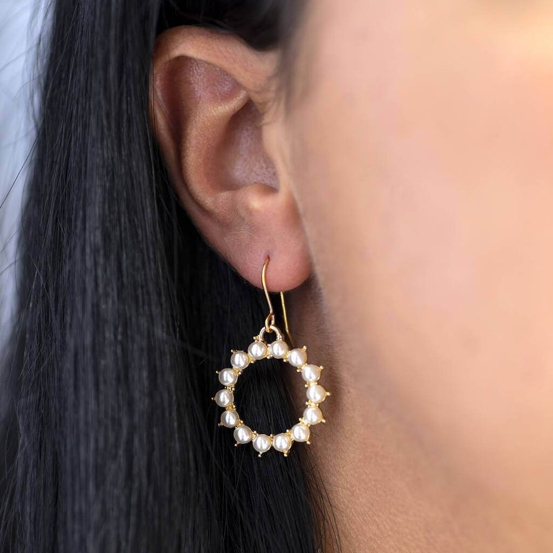 Model wears gold pearl sunburst earring
