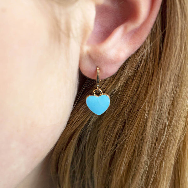 Image shows model wearing Gold Plated Blue Heart Enamel Huggie Hoop Earrings