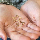Images shows model holiding Gold Plated Star Ear Cuffs