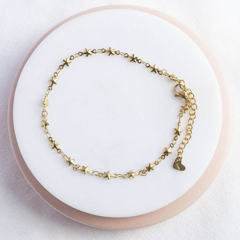 image shows gold plated stars anklet on a white backdrop.