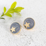 Image shows gold star circle stud earrings in grey