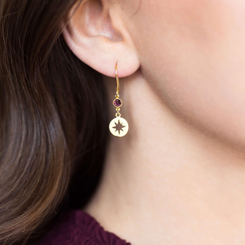 Image shows model wearing Gold Starburst Birthstone Earring with February birthstone