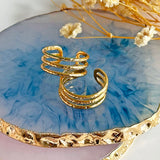 Image show adjustable triple band gold rings on a blue glass background