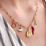 Image shows a model wearing a gold plated charm necklace with assorted charms