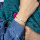 Image shows model wearing silver JOY positive affirmation bracelet